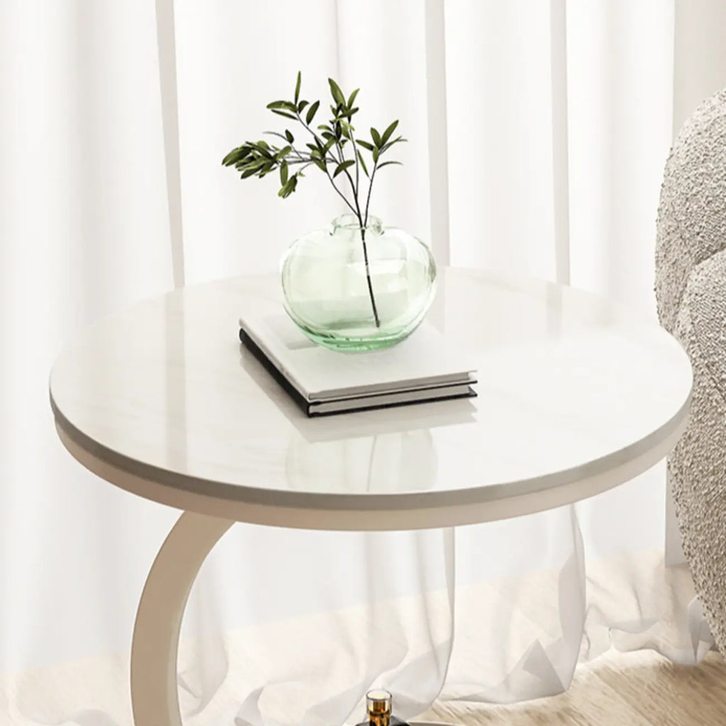 Table d'appoint en forme de C avec plateau en pierre et piètement en métal.