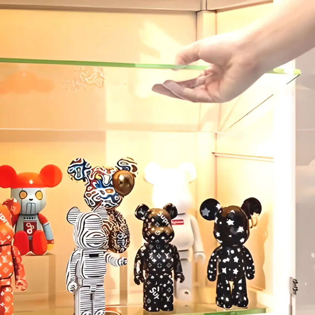 Vitrine d'angle étroite réglable en métal blanc et verre, avec porte-objets en métal et verre.